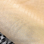 L'image montre un motif de maille délicat et texturé avec des touches de couleur dorée, créant une surface élégante et sophistiquée.