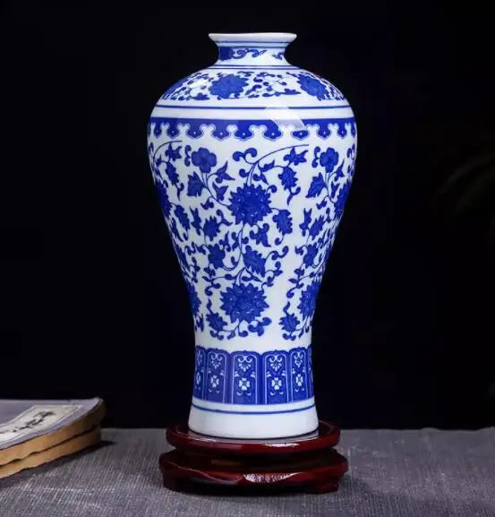 Un vase en porcelaine bleu et blanc orné de motifs floraux élégants, posé sur un support en bois.