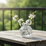 vase verre transparent motif structuré fleurs blanches iris violets table bois nature déco intérieure