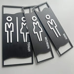 signalisation toilettes moderne symboles homme femme texte TOILET bois brun clair blanc tringle noire