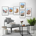 Une collection de peintures aquarelles représentant différentes villes européennes comme Ystad, Stockholm, Cracovie, Gdansk et Florence, créant un décor artistique et inspirant dans cet espace de vie.