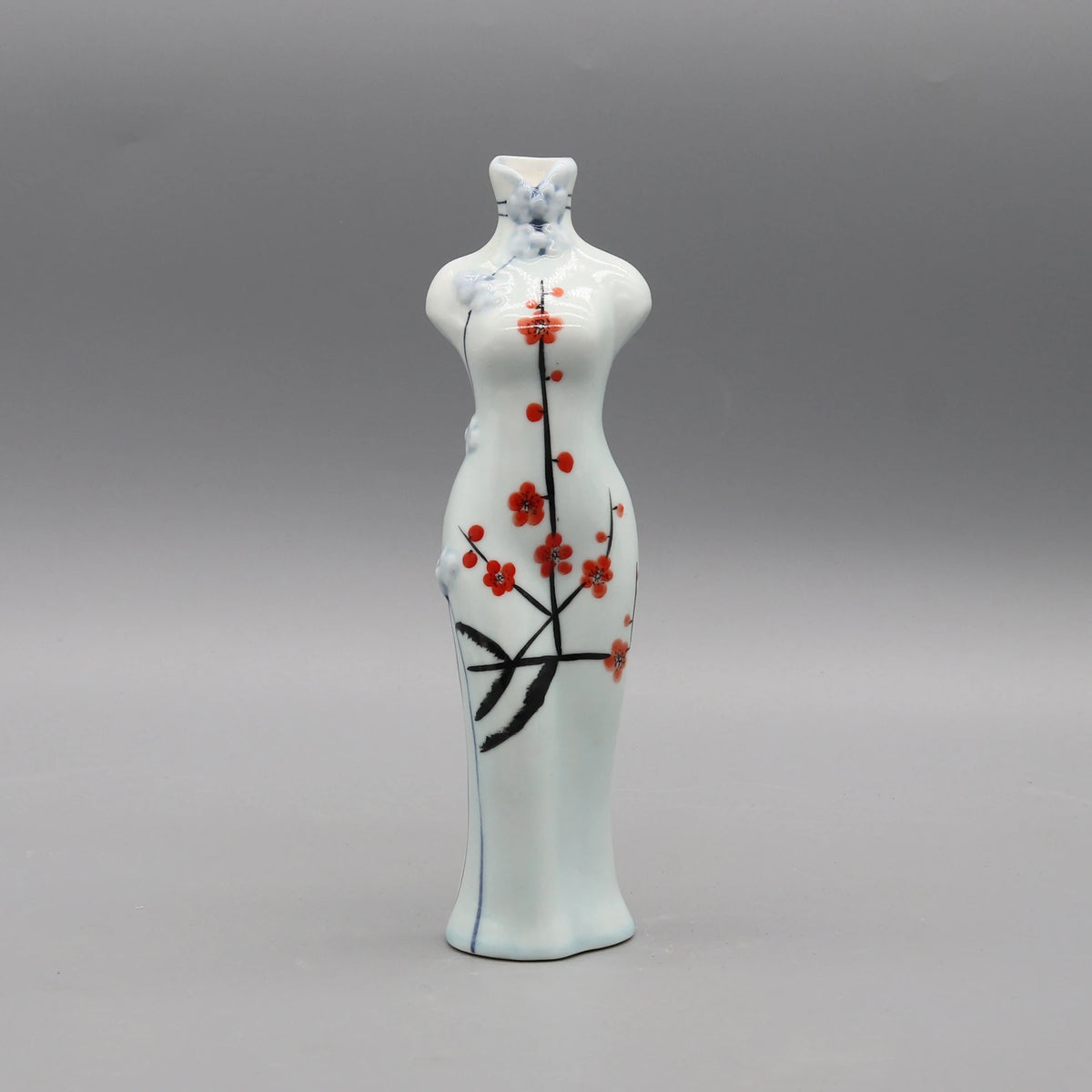 Cette céramique d'art japonaise représente un porte-bougie orné de fleurs de cerisier rouges stylisées sur un fond blanc nacré.