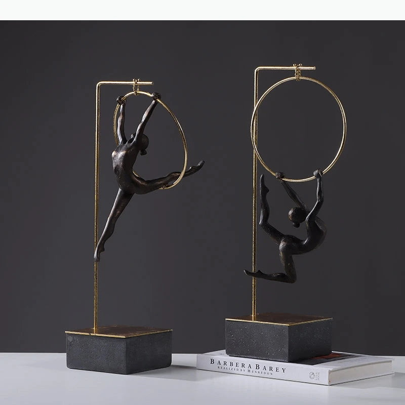 sculpture contemporaine noir doré forme humaine stylisée base transparente anneau métallique minimaliste ornement salon