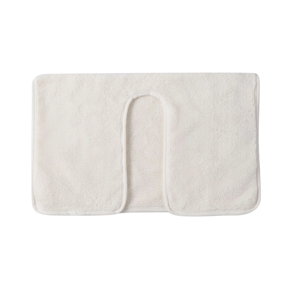 Tapis de bain en tissu doux de couleur crème avec un design minimaliste et une texture douce.