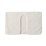 Tapis de bain en tissu doux de couleur crème avec un design minimaliste et une texture douce.