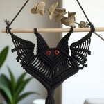 suspension décorative macramé oiseau yeux rouges artisanal noir boho chic barre bois