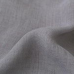 Des rideaux en lin argenté et gris fabriqués en tissu tissé, représentant la qualité supérieure et l'élégance du textile en lin. Ces rideaux sont parfaits pour apporter une touche de sophistication à n'importe quelle pièce tout en offrant une intimité et une protection contre la lumière du soleil. Le thème du textile et de la couleur grise et argentée se reflète dans le design de ces rideaux en lin tissé.