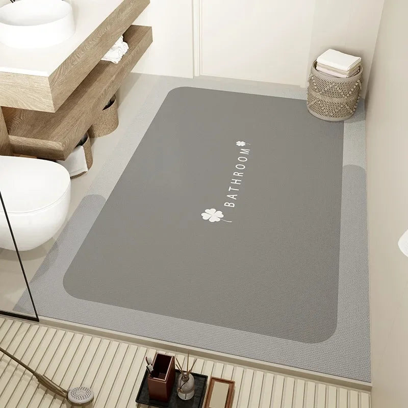 Le tapis de bain gris avec le logo de la marque "Bathroom" en blanc crée une ambiance épurée et chic dans cette salle de bain contemporaine.