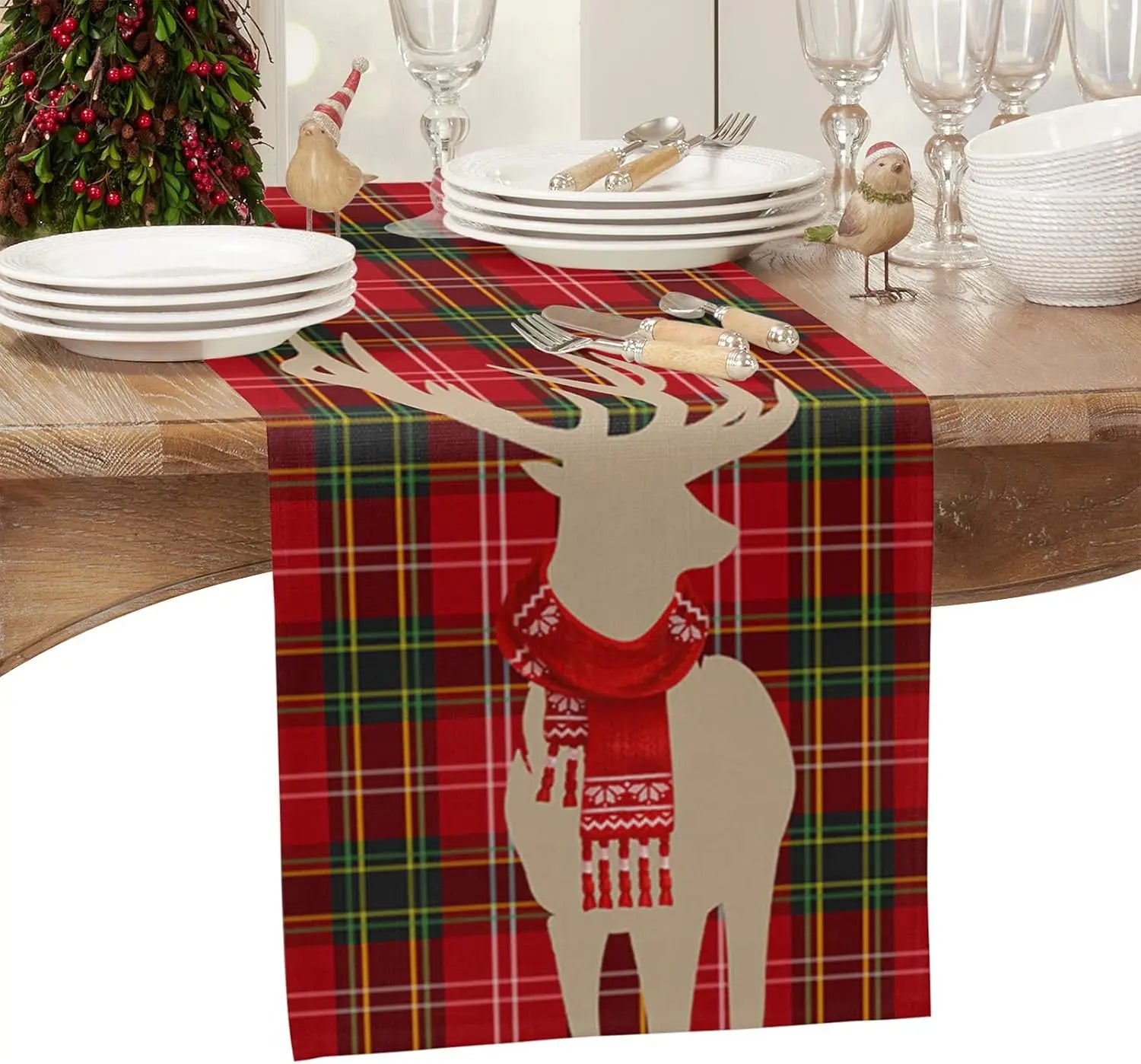 Le centre de la table est décoré d'un chemin de table rouge à carreaux avec une silhouette de cerf stylisée, créant une atmosphère festive et chaleureuse pour les préparatifs du repas de Noël.