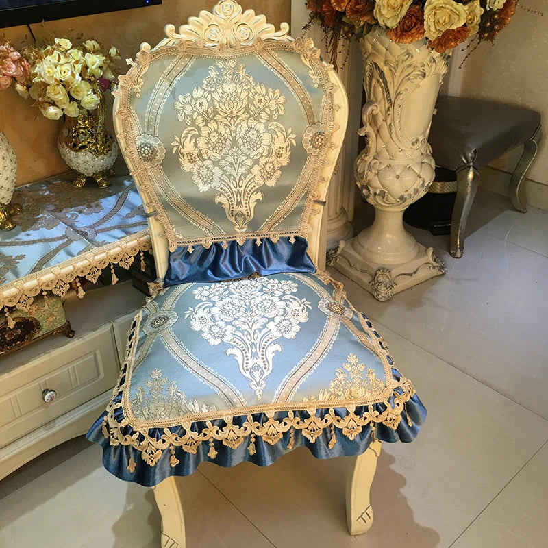 Cette image montre une chaise ornée de motifs floraux et de détails dorés, aux couleurs bleu et beige. La chaise présente un dossier sculpté et un coussin en velours bleu, créant une impression d'élégance et de raffinement.