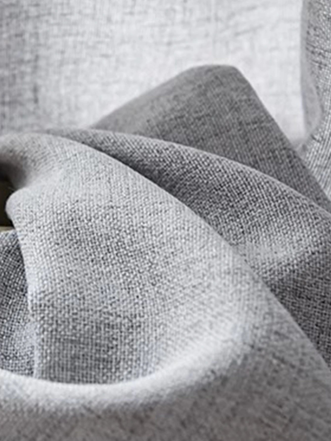 Tissu de voilage gris clair tamisant, froissé pour montrer sa souplesse et son aspect naturel.