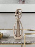 sculpture couple enlacé moderne beige clair doré rouge décoration intérieure vase branches bougies fleurs