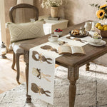 Une table en bois rustique ornée d'un délicat chemin de table avec des motifs papillons, accompagnée de délicieuses collations et d'une tasse de thé, créant une atmosphère chaleureuse et accueillante.