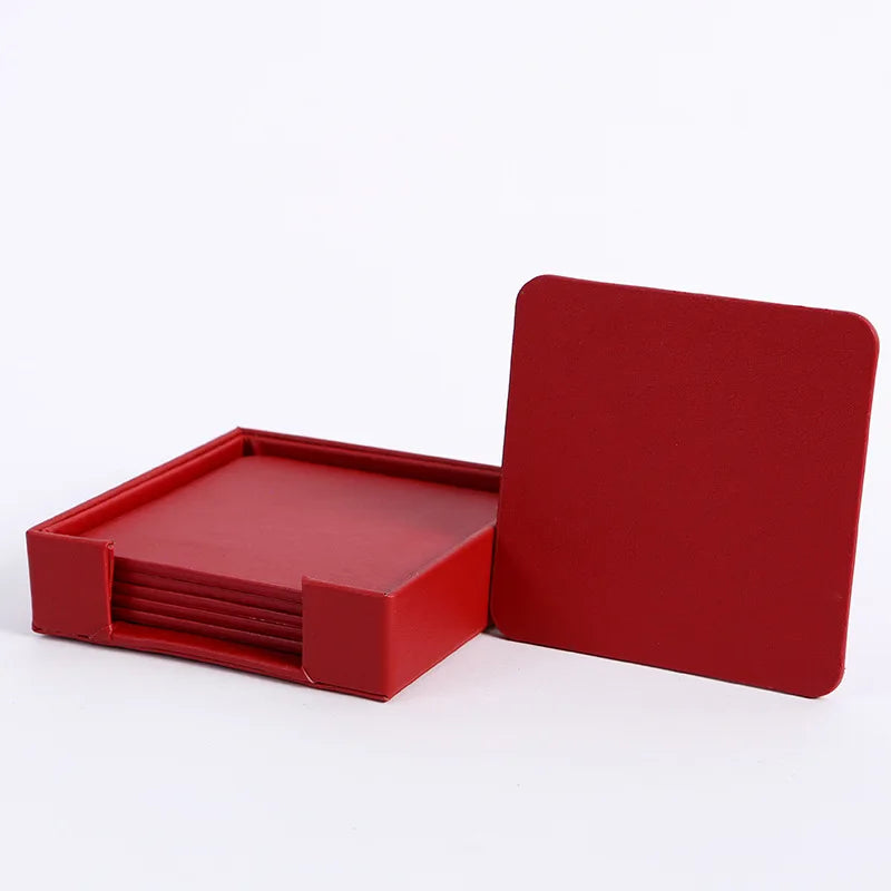 Une pile de sous-verres carrés de couleur rouge vif, rangés dans un support également rouge.