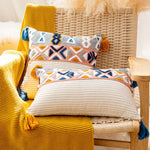 Cette image présente un canapé confortable garni de coussins décorés de motifs géométriques colorés, créant une ambiance chaleureuse et tendance dans cette pièce.