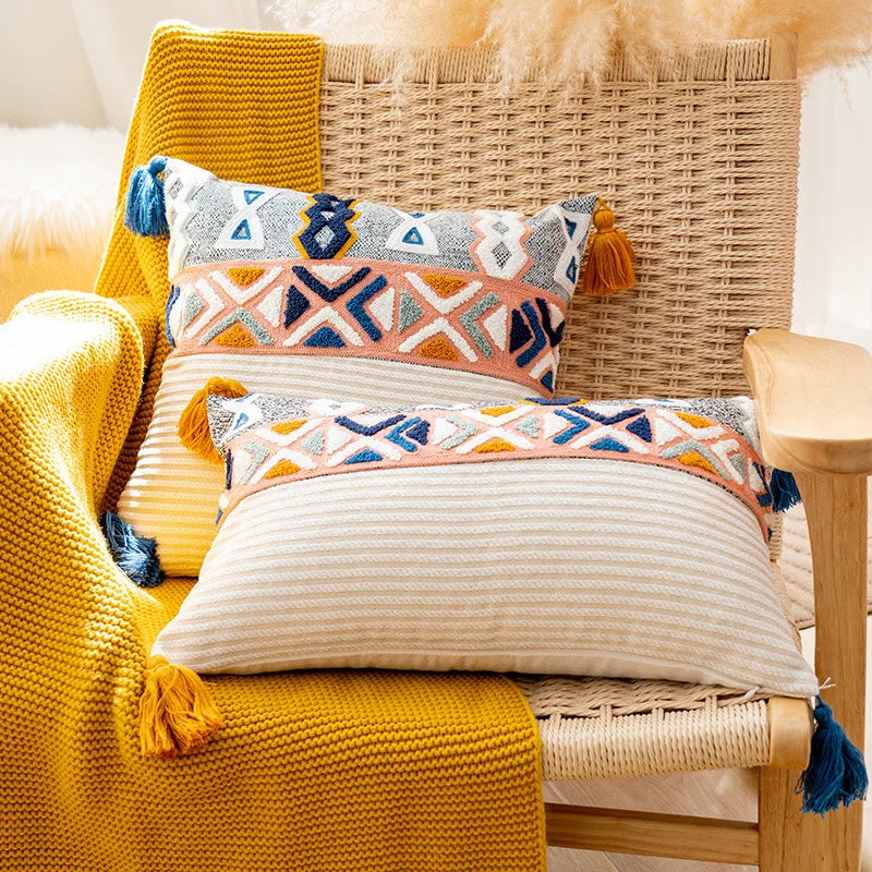 Cette image présente un canapé confortable garni de coussins décorés de motifs géométriques colorés, créant une ambiance chaleureuse et tendance dans cette pièce.