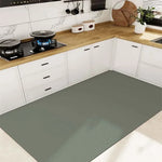 Cuisine moderne avec des armoires blanches, un plan de travail en bois et un sol gris, avec des accessoires décoratifs tels que des plantes et des ustensiles de cuisine.