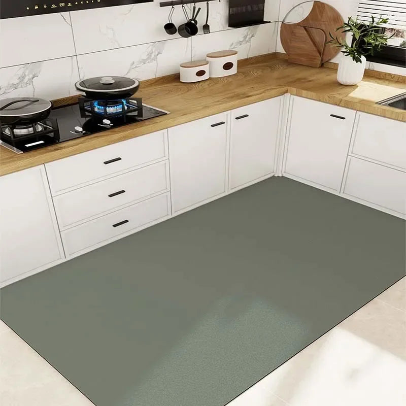 Cuisine moderne avec des armoires blanches, un plan de travail en bois et un sol gris, avec des accessoires décoratifs tels que des plantes et des ustensiles de cuisine.