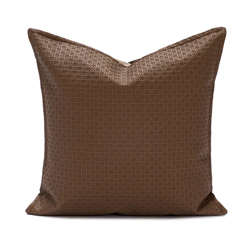 Coussin décoratif brun foncé avec un motif géométrique répétitif.