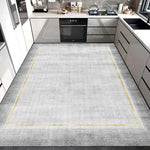 Cette image montre une cuisine moderne avec des meubles blancs et des appareils électroniques, ainsi qu'un sol gris avec des lignes jaunes qui créent un cadre visuel.