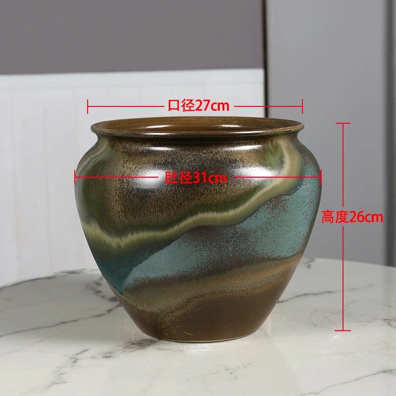 Vase en céramique de forme ronde avec des motifs colorés dans des tons de vert et de brun, mesurant 27 cm de largeur et 26 cm de hauteur.