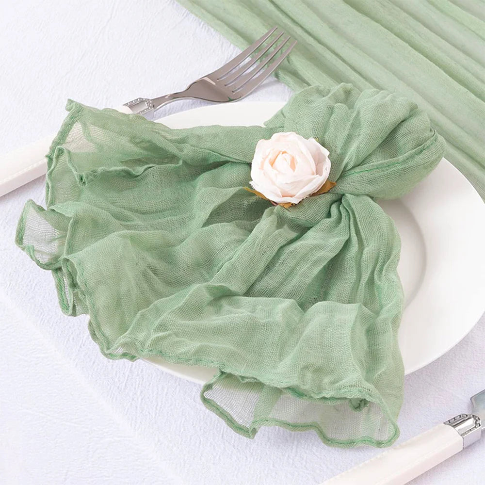 Une belle serviette verte pastel ornée d'une rose blanche sur une assiette blanche avec une fourchette, créant une image élégante et apaisante.