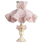 Lampe de chevet rose allumée dans une chambre