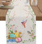 Une nappe de table ornée de motifs floraux et d'oiseaux, avec des œufs de Pâques colorés dans un nid, créant une ambiance printanière et chaleureuse.
