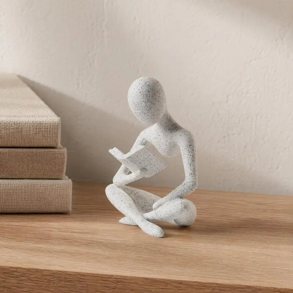 statue décorative moderne figure humaine assise livre blanc noir texturée minimaliste éléments