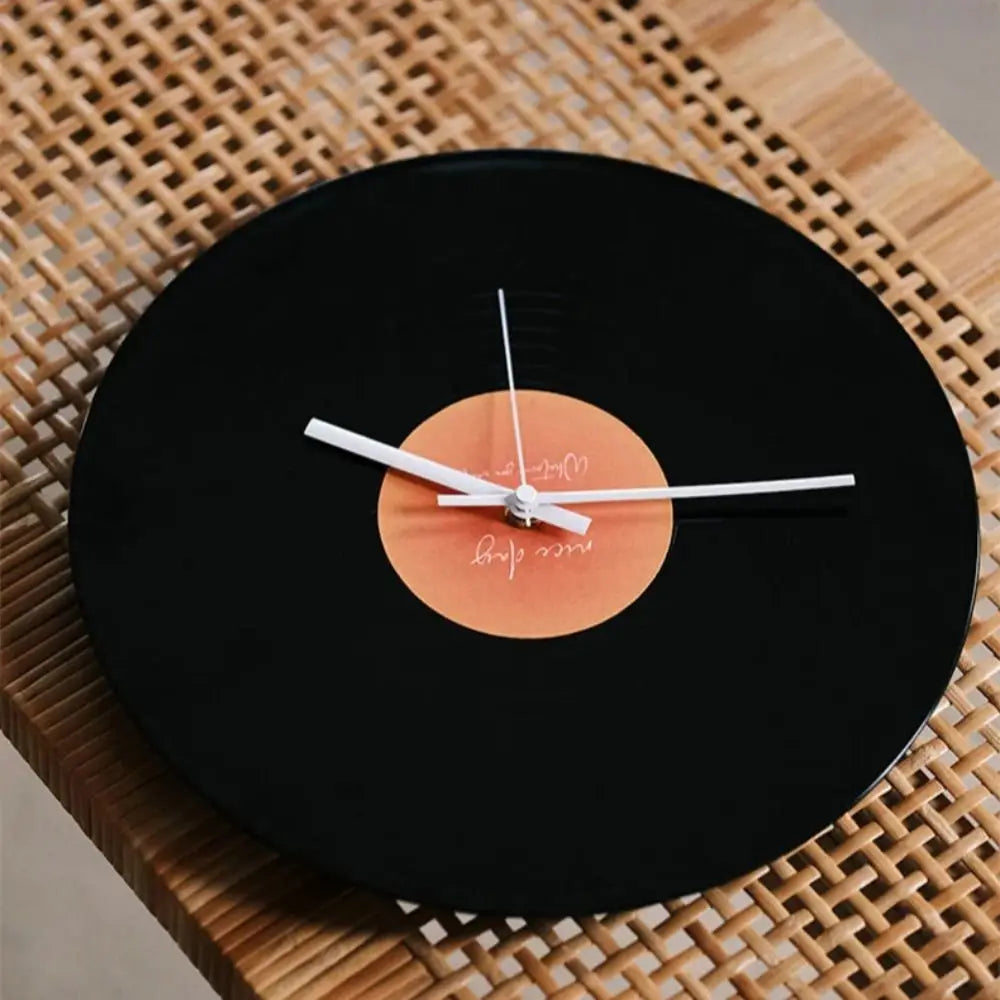 horloge murale vintage disque vinyle noir orange aiguilles blanches support métallique minimaliste moderne decoration