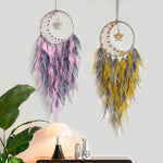 Deux attrape-rêves décoratifs suspendus, l'un rose et gris, l'autre jaune et gris, avec des étoiles et des plumes qui confèrent une ambiance chaleureuse et apaisante à la pièce.