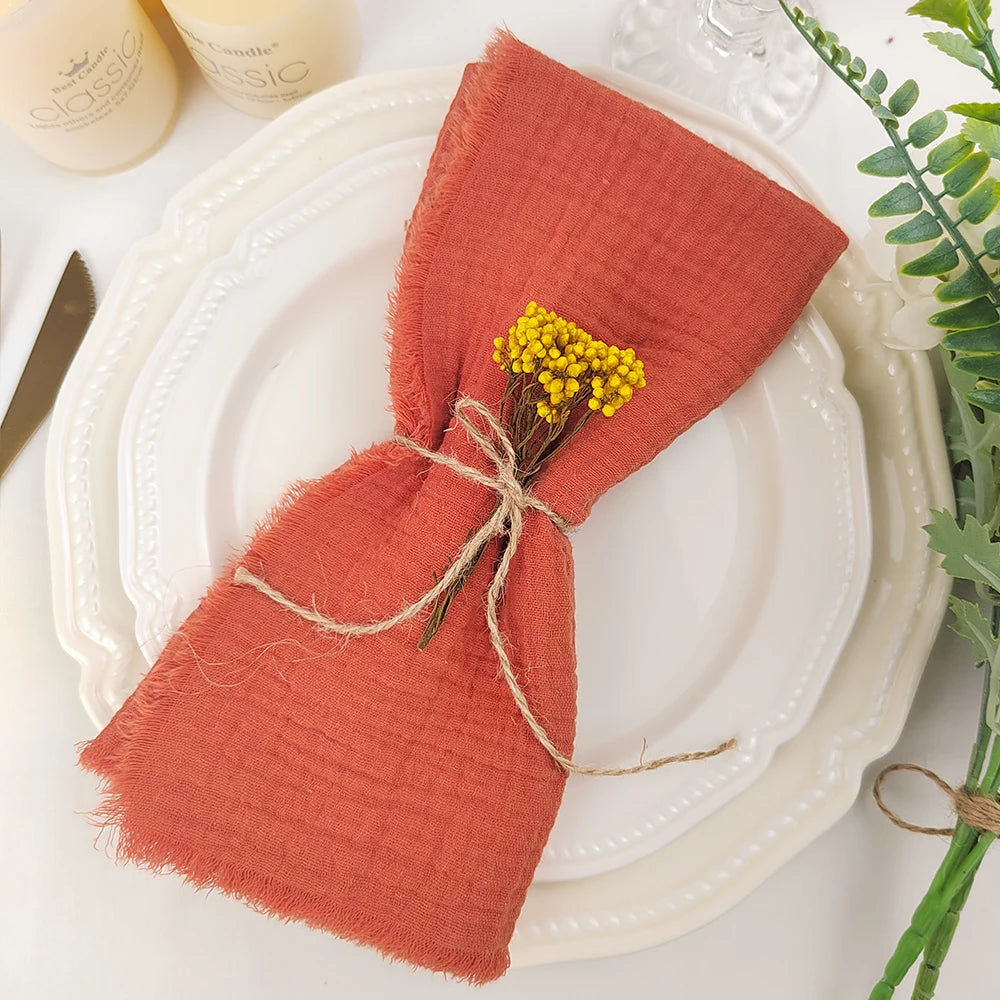 Un élégant arrangement de serviette de table rouge avec un bouquet de fleurs jaunes décoratives, sur une assiette blanche.