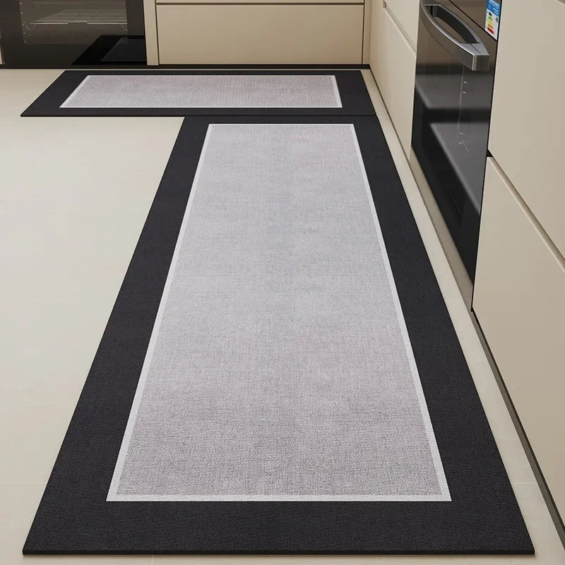 Tapis de cuisine gris et noir posé sur un sol blanc dans une cuisine moderne avec électroménagers.