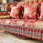 Un canapé somptueux orné de motifs floraux dorés sur un fond rouge vif, rehaussé de franges et de détails raffinés, créant une atmosphère luxueuse et élégante.