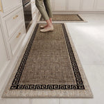 Un tapis de couleur beige et noire avec un motif géométrique décoratif est posé sur le sol d'une cuisine, offrant un accent visuel élégant à l'espace.