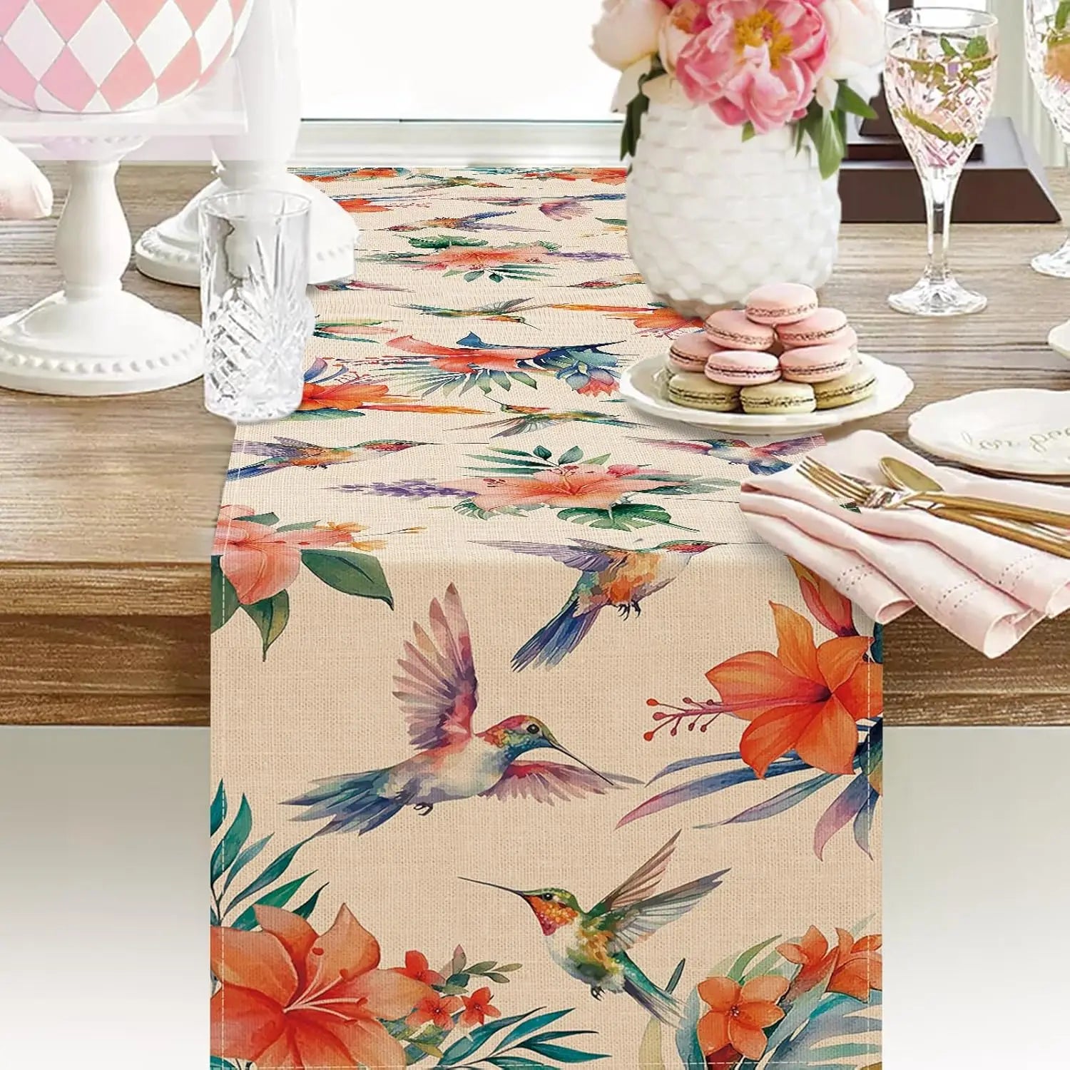 Une jolie table de dîner colorée avec un chemin de table imprimé de fleurs tropicales et d'oiseaux-mouches.