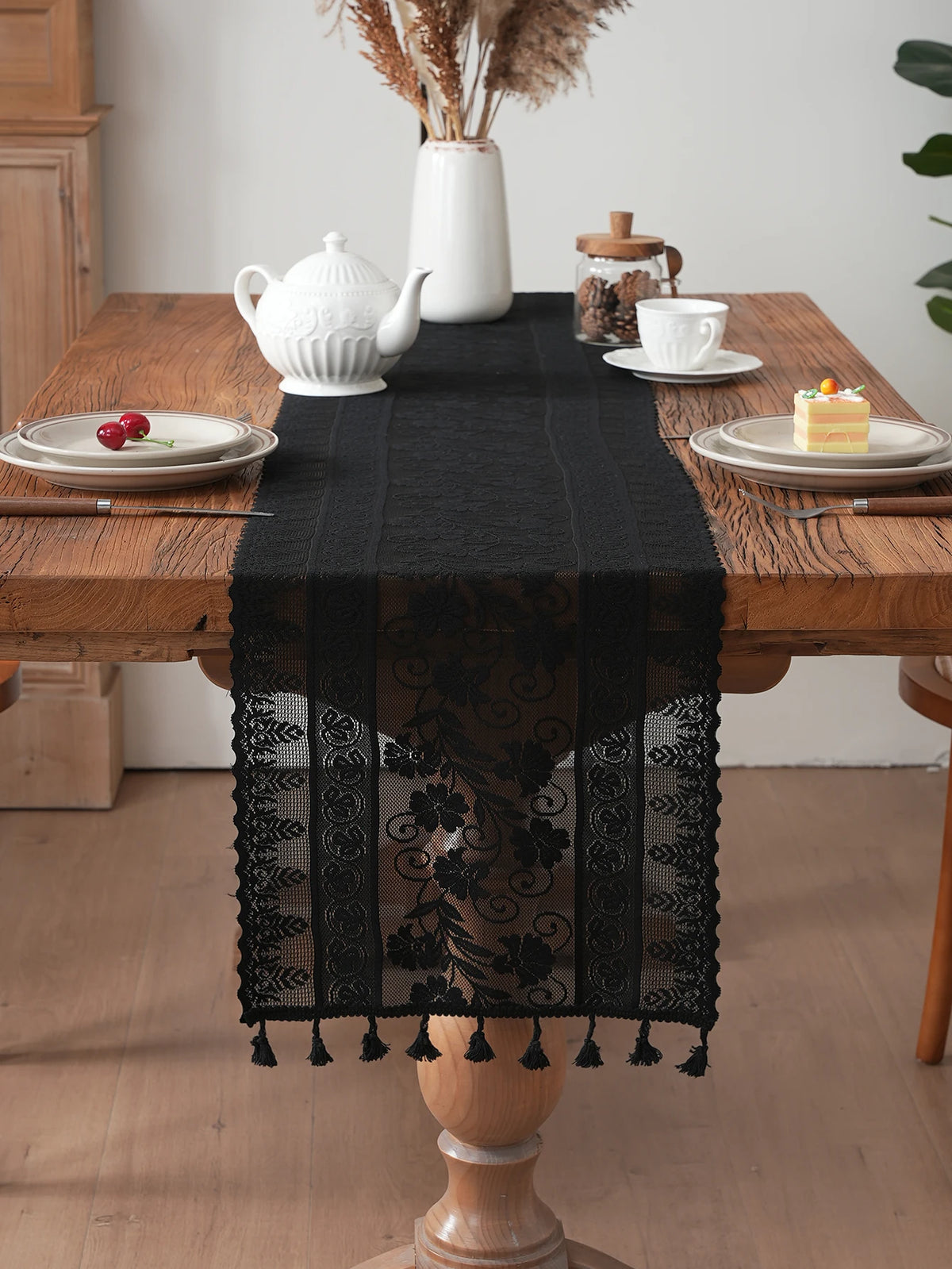 chimene table noir dentelle motif floral bordures franges assiettes couverts tasse théière gâteau cerises