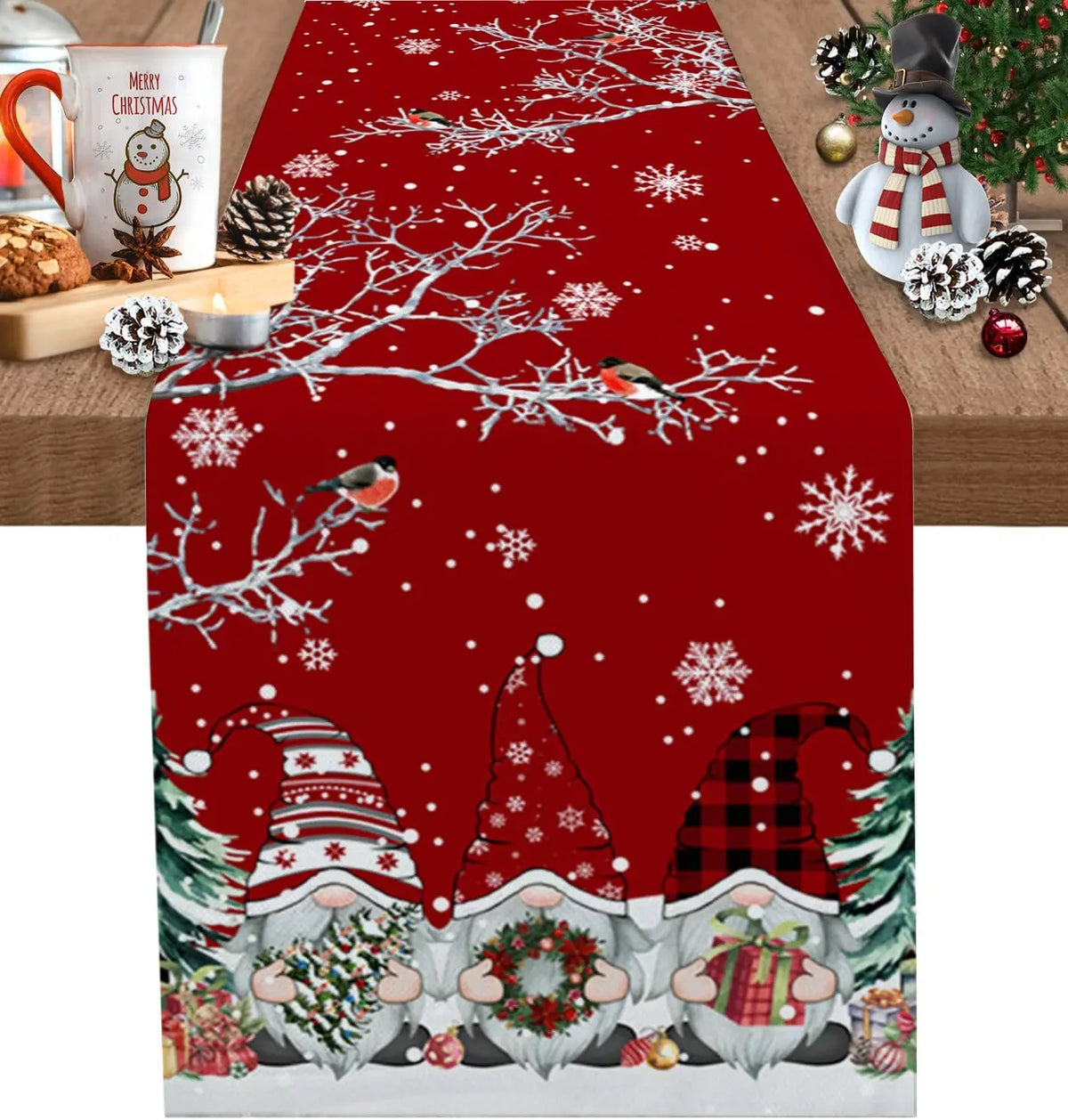 Un chemin de table décoré de motifs de Noël avec des gnomes, des flocons de neige et des branches d'arbres enneigés sur un fond rouge.