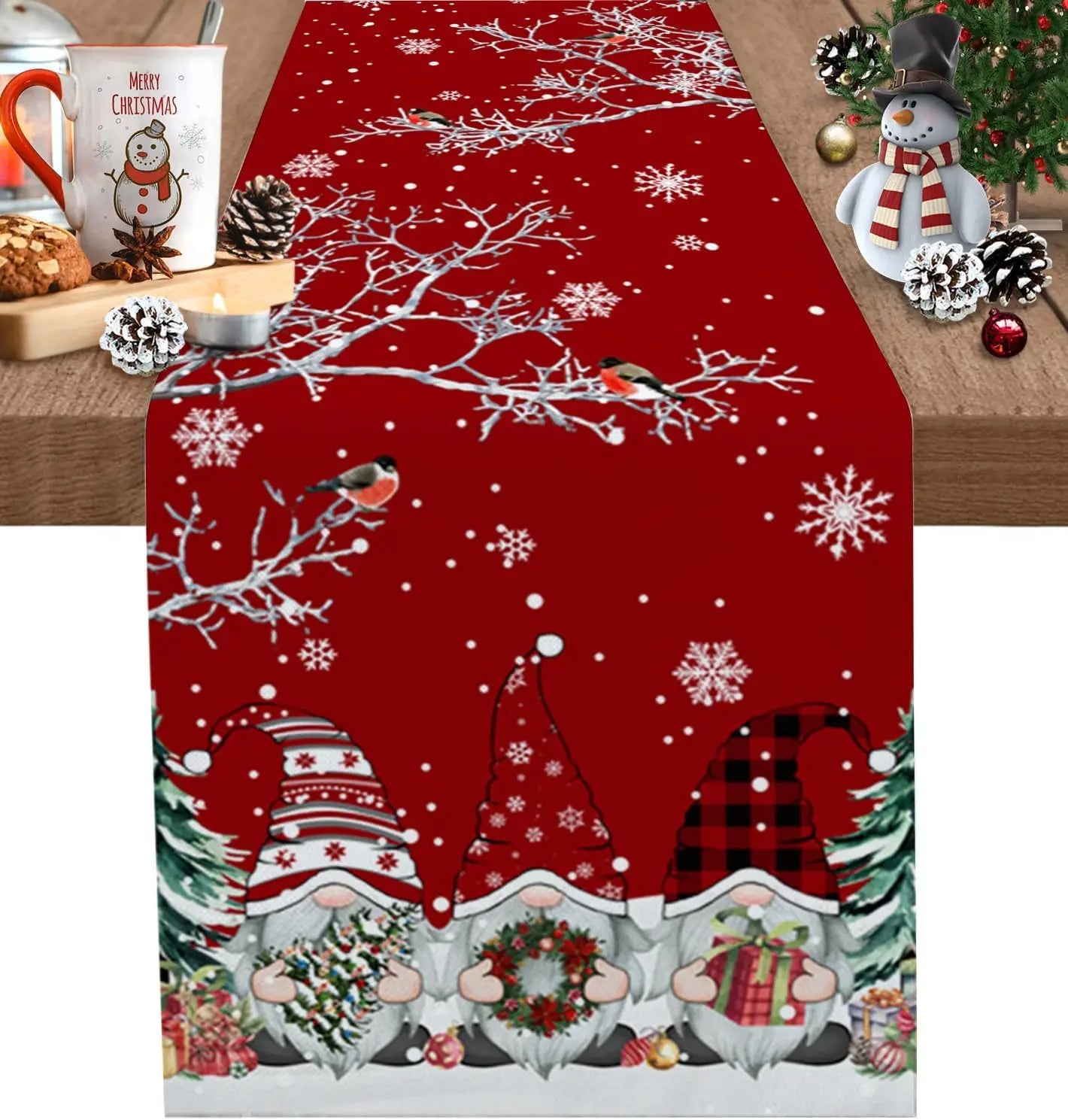 Un chemin de table décoré de motifs de Noël avec des gnomes, des flocons de neige et des branches d'arbres enneigés sur un fond rouge.