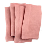 Des serviettes de bain en lin rose pâle, douces et texturées, offrant une expérience de luxe dans la salle de bain.