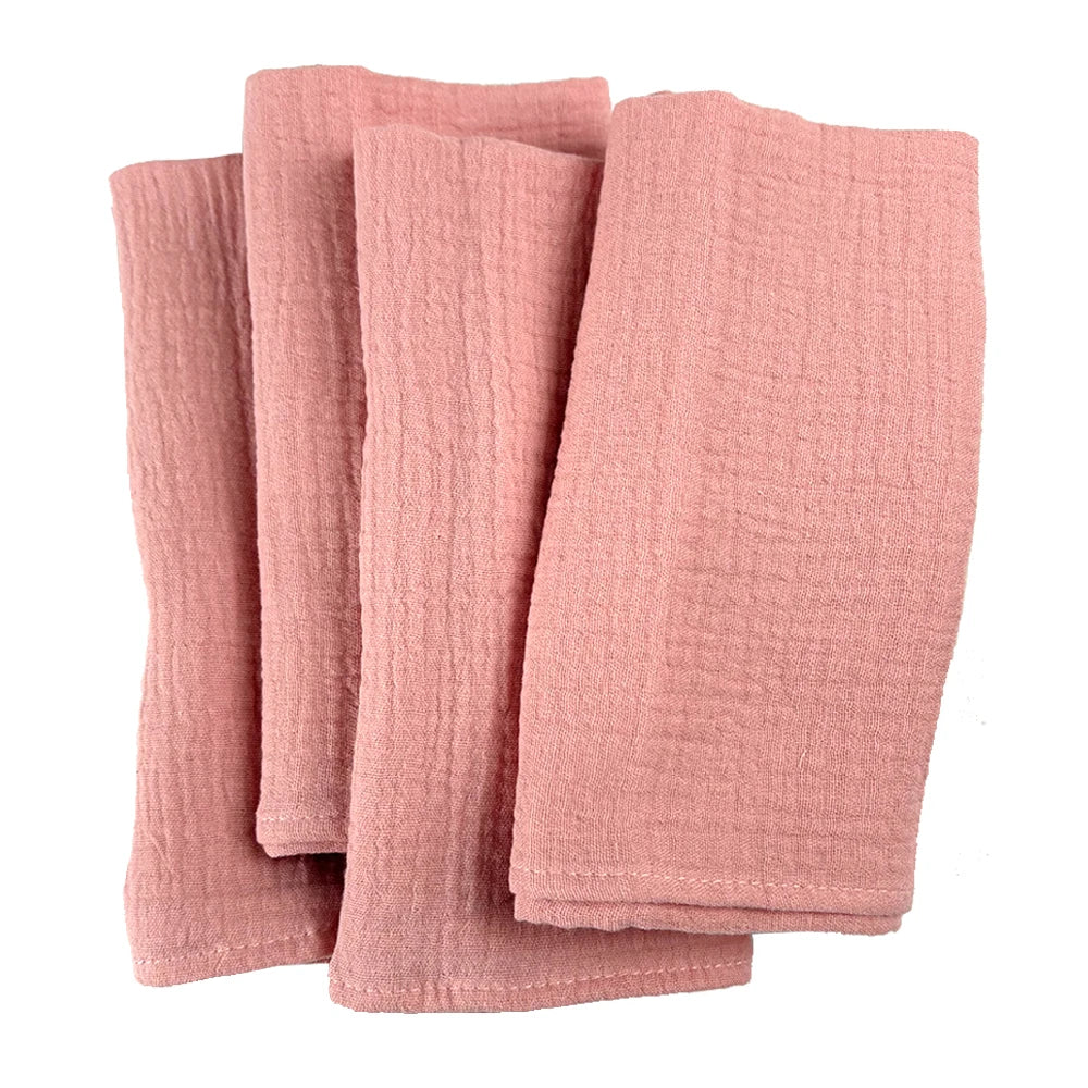 Des serviettes de bain en lin rose pâle, douces et texturées, offrant une expérience de luxe dans la salle de bain.