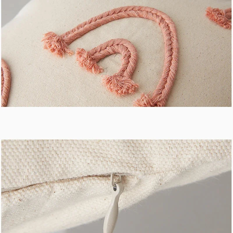 Un coussin décoratif en coton écru orné de motifs tressés en fil orange, créant un design simple et élégant.