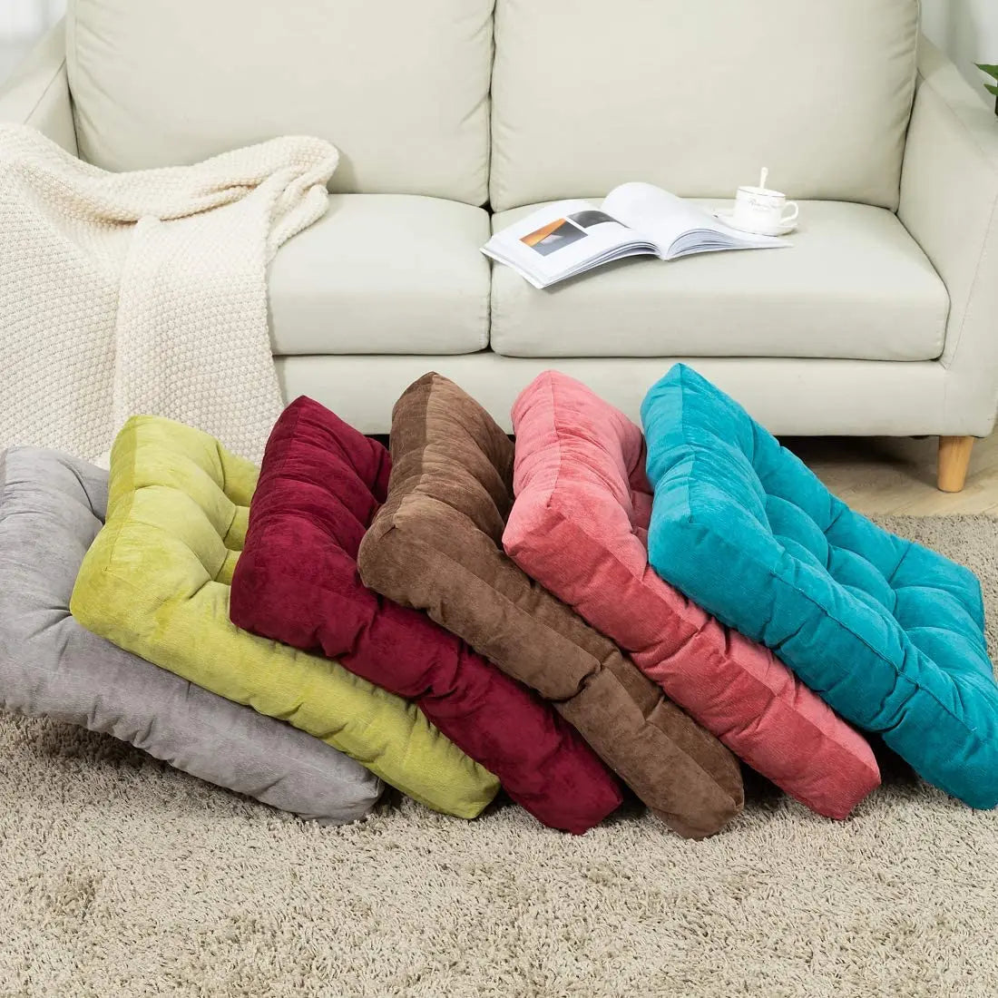 Coussin de sol rouge placé sur une terrasse en bois