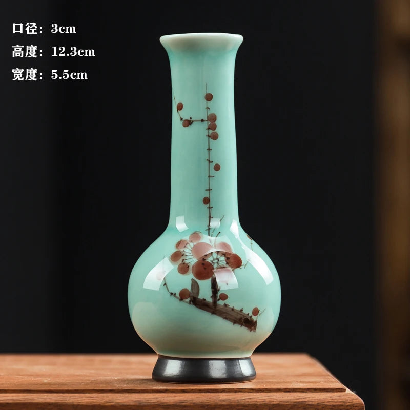 Un vase en céramique d'une forme élégante et épurée, orné de motifs floraux délicats aux tons pastels sur un fond vert clair.