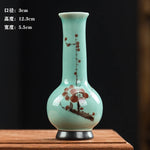 Un vase en céramique d'une forme élégante et épurée, orné de motifs floraux délicats aux tons pastels sur un fond vert clair.