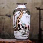 Une élégante vase en porcelaine décorée de magnifiques pandas, entourés de pins et de neige, créant une scène paisible et harmonieuse.