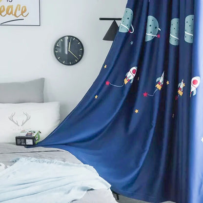 Rideau occultant bleu foncé pour chambre d'enfant avec motifs spatiaux, fusées et étoiles, créant une ambiance ludique et apaisante, idéal pour une décoration sur le thème de l'espace. Atmosphère confortable et attrayante pour les jeunes explorateurs.