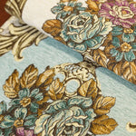 Un tissu brocart richement décoré de motifs floraux aux couleurs chaudes et éclatantes, créant une atmosphère élégante et luxueuse.