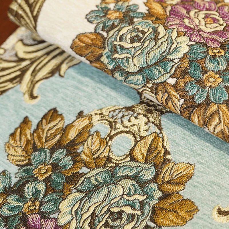 Un tissu brocart richement décoré de motifs floraux aux couleurs chaudes et éclatantes, créant une atmosphère élégante et luxueuse.