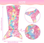 Coussin en forme de queue de sirène avec motif d'arc-en-ciel et d'étoiles sur fond rose.